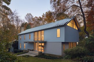 A fiber cement "wrapper" clads the addition and the renovated home, which now totals 3,300 square feet. A translucent plexiglass canopy defines the new glassed entry. The front right corner, finished with contrasting local Atlantic white cedar, denotes a work room that serves the storage purposes of the previous garage.