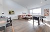 Modern home with Dresser, Carpet Floor, Bed, Chair, Engineered Quartz Counter, Undermount Sink, Ceiling Lighting, Ceramic Tile Wall, Two Piece Toilet, Trees, Shrubs, Grass, Walkways, Back Yard, Large Patio, Porch, Deck, Sofa, Stools, Concrete Floor, Table, and Pendant Lighting. loft Photo 15 of Cedarbrook Net Zero Modern