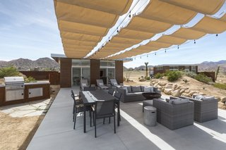 This Modern Homestead With a Vintage Trailer Offers Adventure in California's High Desert - Photo 1 of 10 - Owner Dave McAdam started Blue Sky Building Systems, whose steel-frame system easily adapts to sloped lots, before founding Homestead Modern, whose pre-designed homes can be built nearly anywhere for a set price. Above, a shaded patio off the main house enjoys access to a fire pit and a grill.
