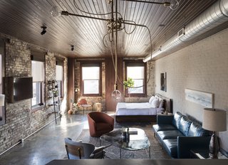 History and Modernity Meet in This Industrial Hotel and Restaurant in Philadelphia - Photo 2 of 11 - Room 1, located on the second floor, blends industrial detailing with exposed brick walls, polished concrete floors, rich textile finishes, and a custom walnut bed. 