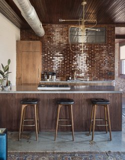 History and Modernity Meet in This Industrial Hotel and Restaurant in Philadelphia - Photo 3 of 11 - In the kitchenette area, seamless walnut cabinets, poured concrete countertops, and glazed brick tiles introduce minimalistic, modern elements.