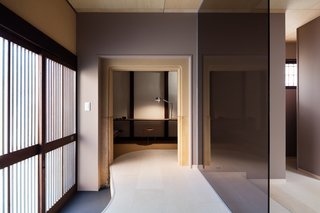 A Minimalist Townhouse Provides Serene Accommodations in Historic Kyoto - Photo 5 of 12 - Clean lines and sophisticated colors with reds, purples, and browns fill the interior. An office space with a desk and couch is provided on the first floor.