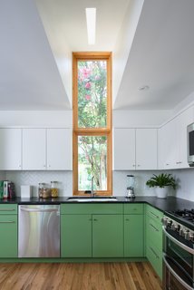 Bringing Light Into a Modest 1940s Bungalow in Austin - Photo 9 of 10 - A tall, slender window in front of the sink creates a built in light well, allowing daylight to reflect further inward. 