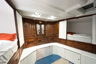 The bunk room provides built-in sleeping quarters within the original woodwork. 