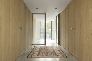 Rough oak cabinetry frames the corridor that leads between the communal areas and the private beds and baths. 