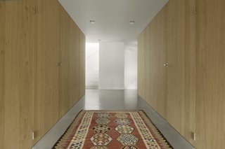 The white stair ascends upward as a light-filled, sculptural element.
