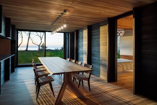 A Dramatic Cantilevered Roof Creates a Spacious Terrace Overlooking Lake Michigan - Photo 7 of 11 - The dining space, with glass on one end, connects the bedroom with the main living spaces. 