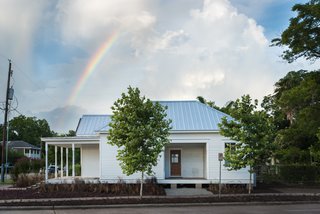 The renovated west facade of the home displays both the front and unique side porch.