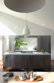 The kitchen sits as a modern insert in the open living space. 