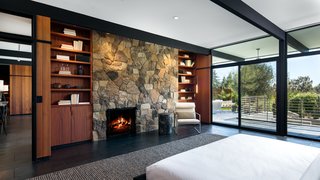 An Award-Winning Midcentury Residence in Los Angeles County Asks $3.9M - Photo 6 of 17 - Built-in bookshelves frame each side of the stone fireplace. 