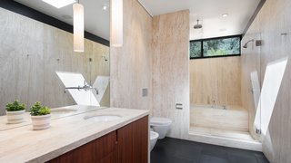 An Award-Winning Midcentury Residence in Los Angeles County Asks $3.9M - Photo 7 of 17 - Natural tile brings the natural elements into the luxurious bath while transom windows bring in daylight. 