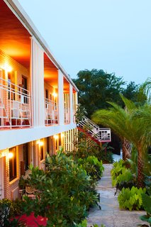 Vertical wood screens and white metal guards decorate the second floor balcony. 