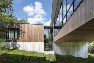 Stained tongue-and-groove Western red cedar siding wraps the upper volume. 