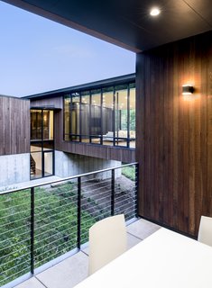 Despite large amounts of glass, the house provides spaces of refuge. The outdoor patio is nestled into the hillside, sheltered by the landscape and building. 