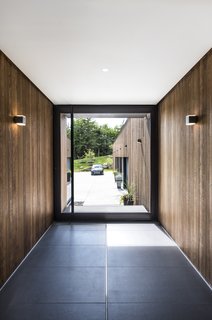 Cedar walls and Bega wall sconces seamlessly extend from exterior to interior. 