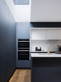 A Sleek Renovation in London Ushers Light Into a Family Home - Photo 6 of 11 - Plywood covered with Fenix NTM forms the kitchen cabinetry and surfaces. A Cascata satin bronze tap by Olif adds a metallic element.