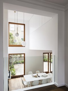 A Sleek Renovation in London Ushers Light Into a Family Home - Photo 2 of 11 - Large windows fill the main living and dining space with natural light. FLOS IC Pendant Lights hang in the double height space. 