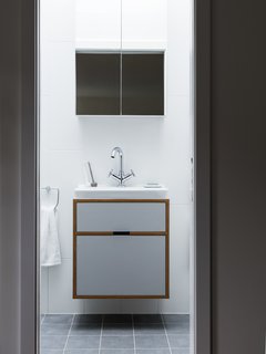 A Sleek Renovation in London Ushers Light Into a Family Home - Photo 9 of 11 - A floating bath vanity is composed of the same plywood detailing. 