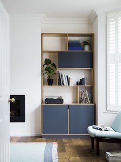 A Sleek Renovation in London Ushers Light Into a Family Home - Photo 10 of 11 - A darker blue hue adds richness to the built in casework in the living space. 
