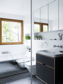 A Sleek Renovation in London Ushers Light Into a Family Home - Photo 5 of 11 - Patterned porcelain floor tiles add an unexpected pop in the bathroom. 