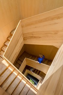 The wood-framed stair extends from the entry way to the rooftop terrace, connecting all levels and spaces. Lit from above, daylight splashes against each floor level. 