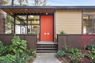 A midcentury modern color palette decorates the exterior. Brightly colored doors highlight the home's entry. 