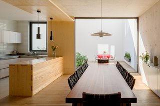 Arrullo Chairs surround an Arrullo Dining Table, both by Oscar Hagerman. Pendant Light JL341 by Juha Leviska hangs delicately above the wooden table. 