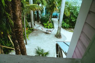 Forget Coworking—These Coliving Spaces Let You Travel the World For $1,800 a Month - Photo 4 of 25 - Roam Miami sandy garden with hammock 