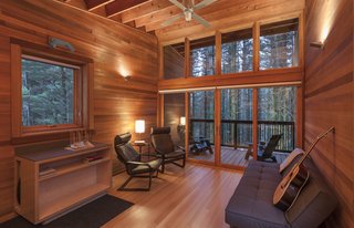 Cedar wood seamlessly extends from inside to outside, connecting to the woods beyond. Adirondack chairs provide the perfect viewing point from the balcony. 