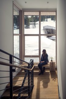 These Contemporary Lake Tahoe Chalets Have Ski-In, Ski-Out Access - Photo 5 of 11 - Adjacent to the staircase, large spans of glazing frame views to the slopes beyond. Wood stair treads and a steel guardrail modernize the circulation space. A George Nelson bench sits below the window, decorated by a Ohio Design Blocky. 