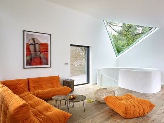 An orange Ligne Roset sofa provides a comfortable space for rest and relaxation. 