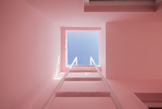 A built-in ladder provides access to the roof deck. The blue skies contrast with the light pink walls, creating a pastel composition of solids and voids.
