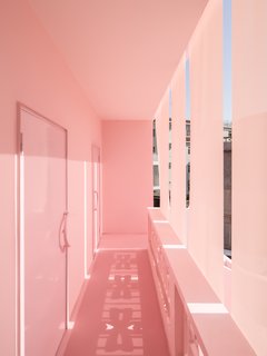 The veil of curtains, which lies on the exterior of the original balcony rails, create a unique brise soleil spatial solution.