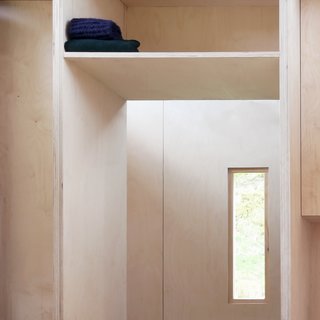 All storage and shelving is meticulously integrated into the overall design. A shelf above the bath provides storage for hiking packs.