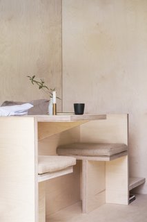 A built in seat and table lies behind the head of the bed, providing a quaint dining space.