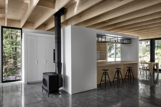 The kitchen is framed by two white walls which link to the adjoining spaces.