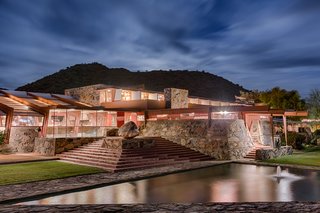 The spaces are connected through terraces, gardens, and pools. Heavy stone walls are balanced with the redwood form work and delicate canvas roof.