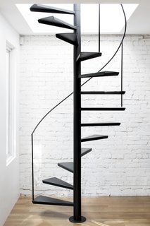 An interior, custom-made steel staircase with floating treads and a minimal handrail leads to the roof deck above.