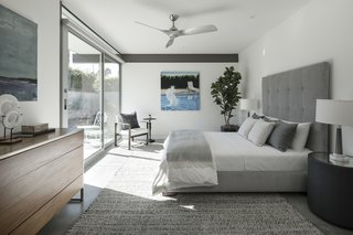 One of the three bedrooms emotes a comfortable, relaxing feel with plush textiles and bedding. Again, full-height glazing brings the outdoor sunshine in.