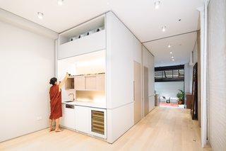 A Steel Staircase Merges Two Units Into One in Tribeca - Photo 3 of 13 - A volumetric mass within the raft area conceals a powder room and guest bath, while displaying the wet bar, complete with a wine rack.