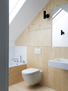 Wooden panels provide a contrast of warmth against the white walls and fixtures. The clean lines and industrial materials combined with an innate understanding of the building's context result in a chic, contemporary dwelling that brings back to life a forgotten piece of property.