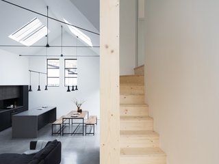 The wooden staircase winds its way between the living space and sleeping areas above.