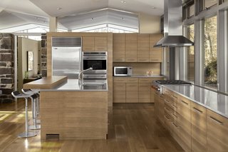 The kitchen cabinets were updated in a pecan finish, in roughly the original layout. Originally, the kitchen had a wall separating it from the rest of the room, and two sliding doors that could be opened. This wall was removed to open the kitchen to the living space.