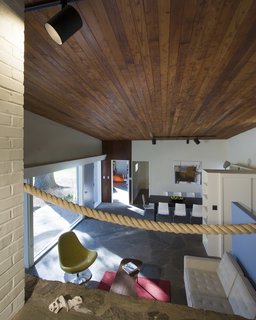 A stained cedar ceiling extends continuously over the living space. The original rope railing remains intact.