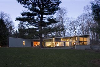 At night, the southern facade glows brightly, revealing the modern interior elements.