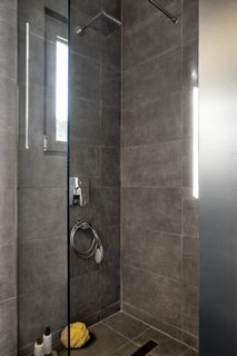 A clean, contemporary shower with a glass screen provides a quaint retreat.