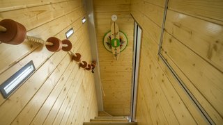Wood walls draw nature in. Unique decorations, such as surfboards and ropes, create a beachy vibe on the interior.