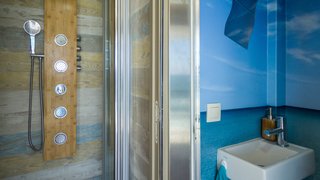 The mobile hotel is complete with a full shower and multiple water pressures. Uniquely decorated with wood planks and a water motif, the shower feels like an ocean retreat.
