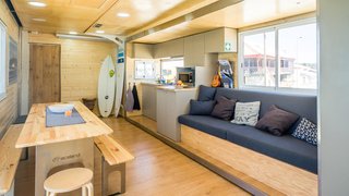 A full kitchen, lounge space, and dining area provide social quarters on the first floor of the bus.