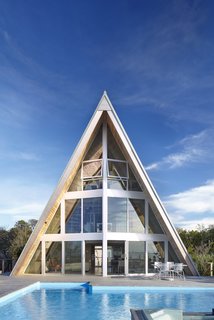 A full-height wall of glazing connects the poolside elements to the interior living spaces.